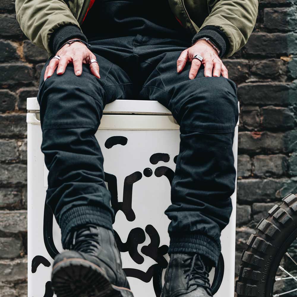 biker wearing black motorbike trousers paired with black motorcycle boots for men