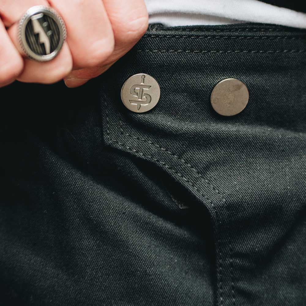 closeup of spada logo buttons on black trousers