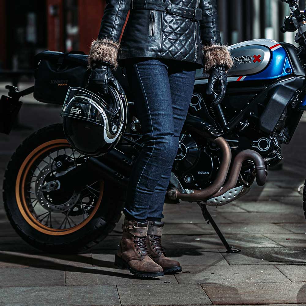 woman biker wearing brown leather motorcycle boots with leather jacket and jeans on motorbike