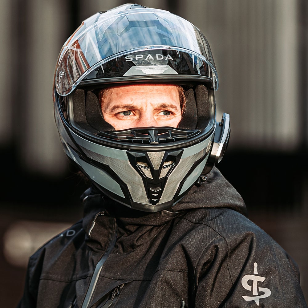 front view of biker wearing black and grey full face motorcycle helmet with visor flipped up