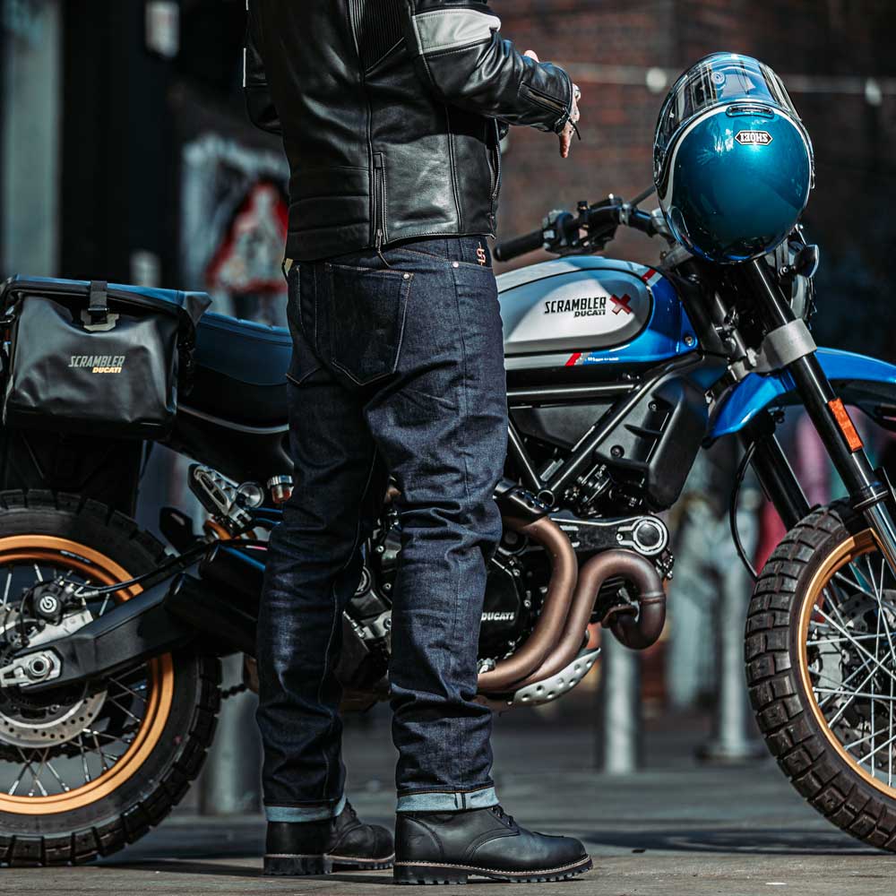 back of biker wearing motorcycle jeans for men with motorbike