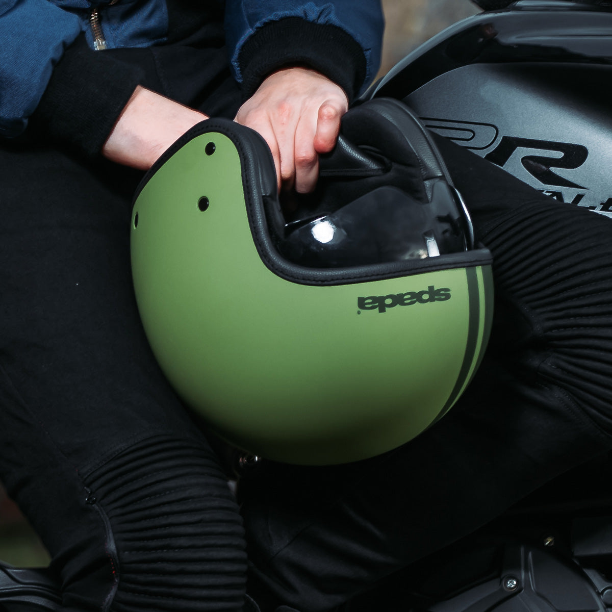 Motorcyclist with a matt green open face motorcycle helmet with CE certification