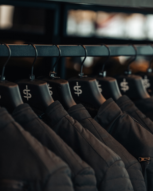 close up of a rail of motorbike jacket with spada branded black hangers