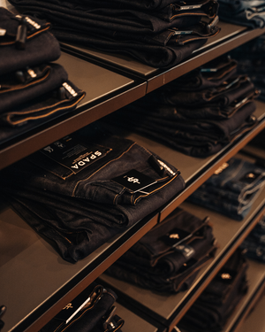 spada motorcycle jeans folded and displayed on shelves in store