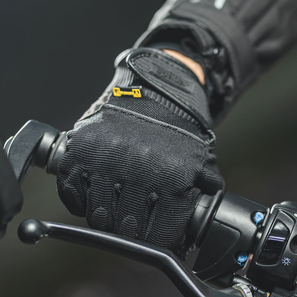 biker wearing textile black motorcycle gloves on a ride while holding handle bars