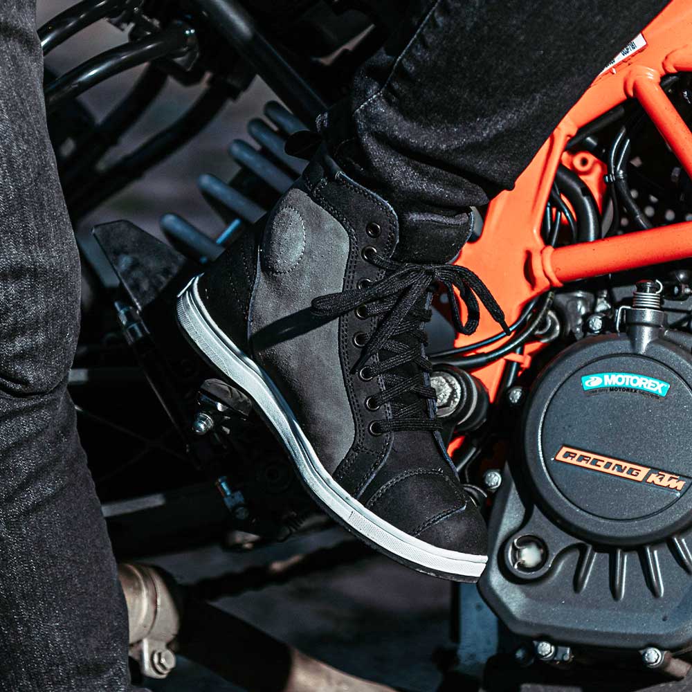 biker wearing black and grey motorcycle trainers with black laces