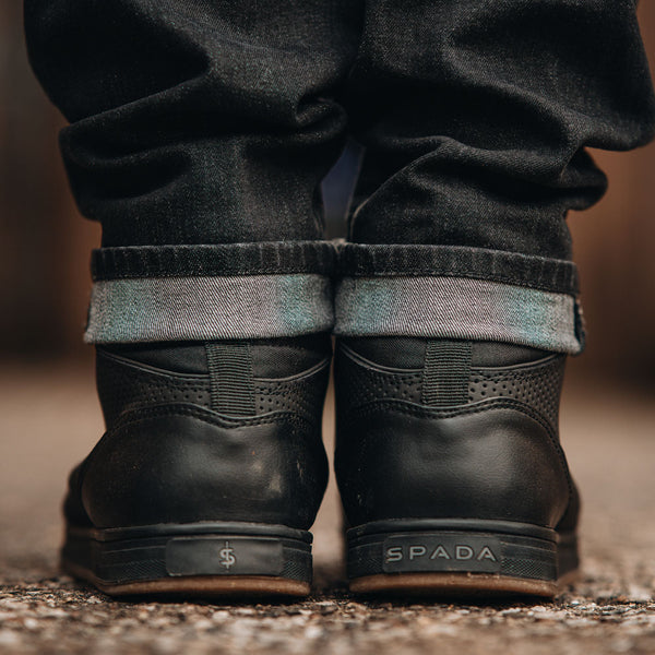back of a pair of black motorcycle trainers paired with biker jeans