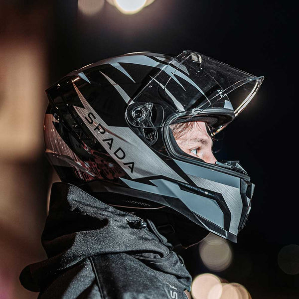 biker wearing black and grey motorbike helmet at night 
