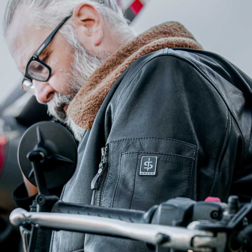 close up of biker wearing black leather motorcycle jacket for men and brown faux collar