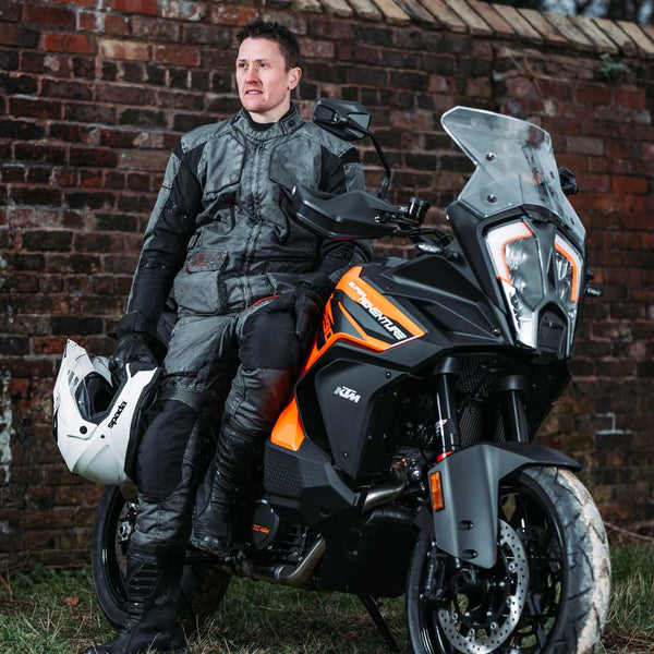 biker wearing grey motorcycle clothing on motorbike