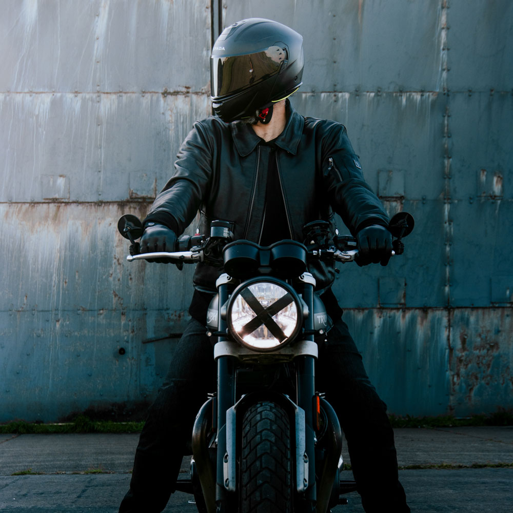 biker in all black with black leather jacket on motorbike with black spada motorcycle helmet