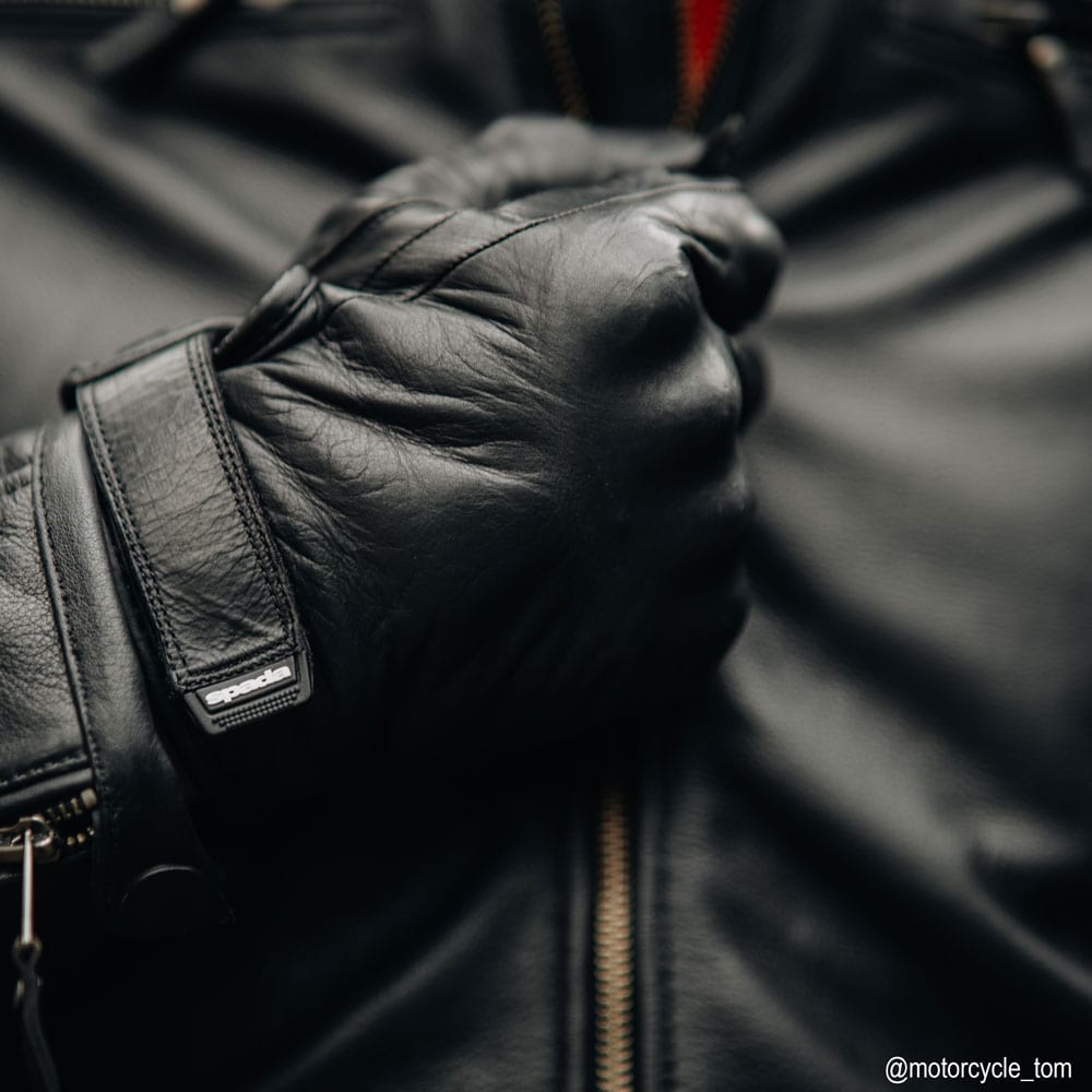 biker wearing black leather motorcycle gloves with black leather motorcycle jacket