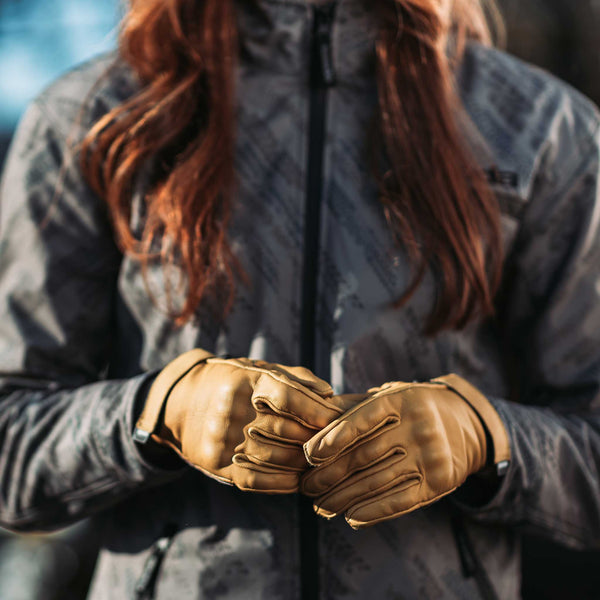 female biker wearing tan yellow leather gloves