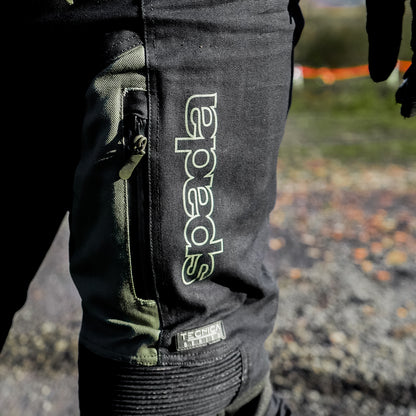 closeup of adventure biker wearing black and olive green motorcycle trousers with waterproof zipped pockets