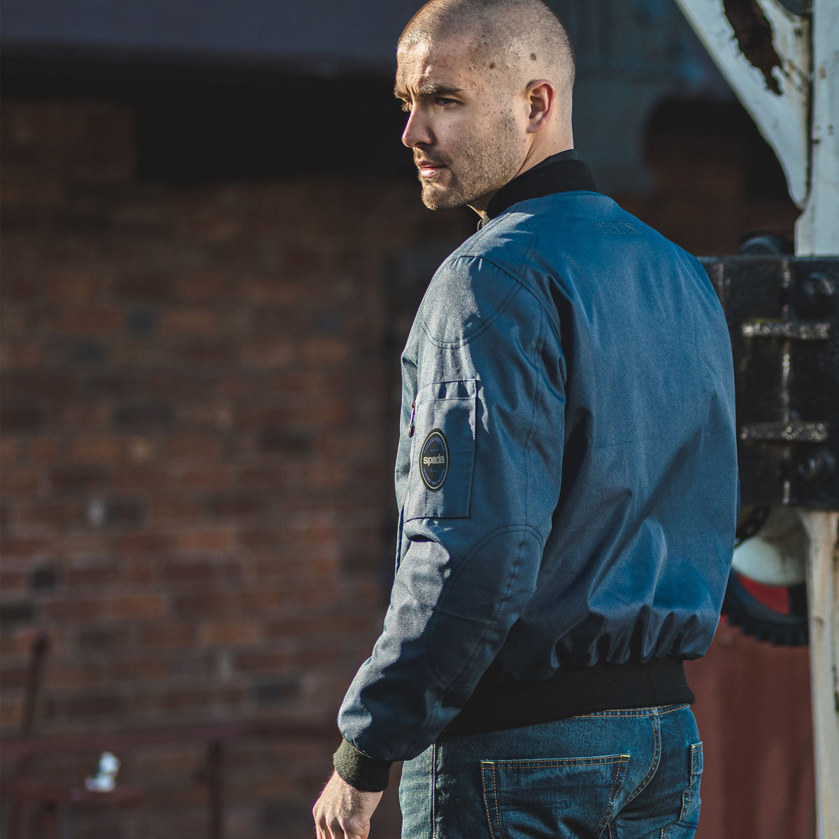 man wearing mens blue bomber jacket for motorcycle riding with a classic and comfortable fit