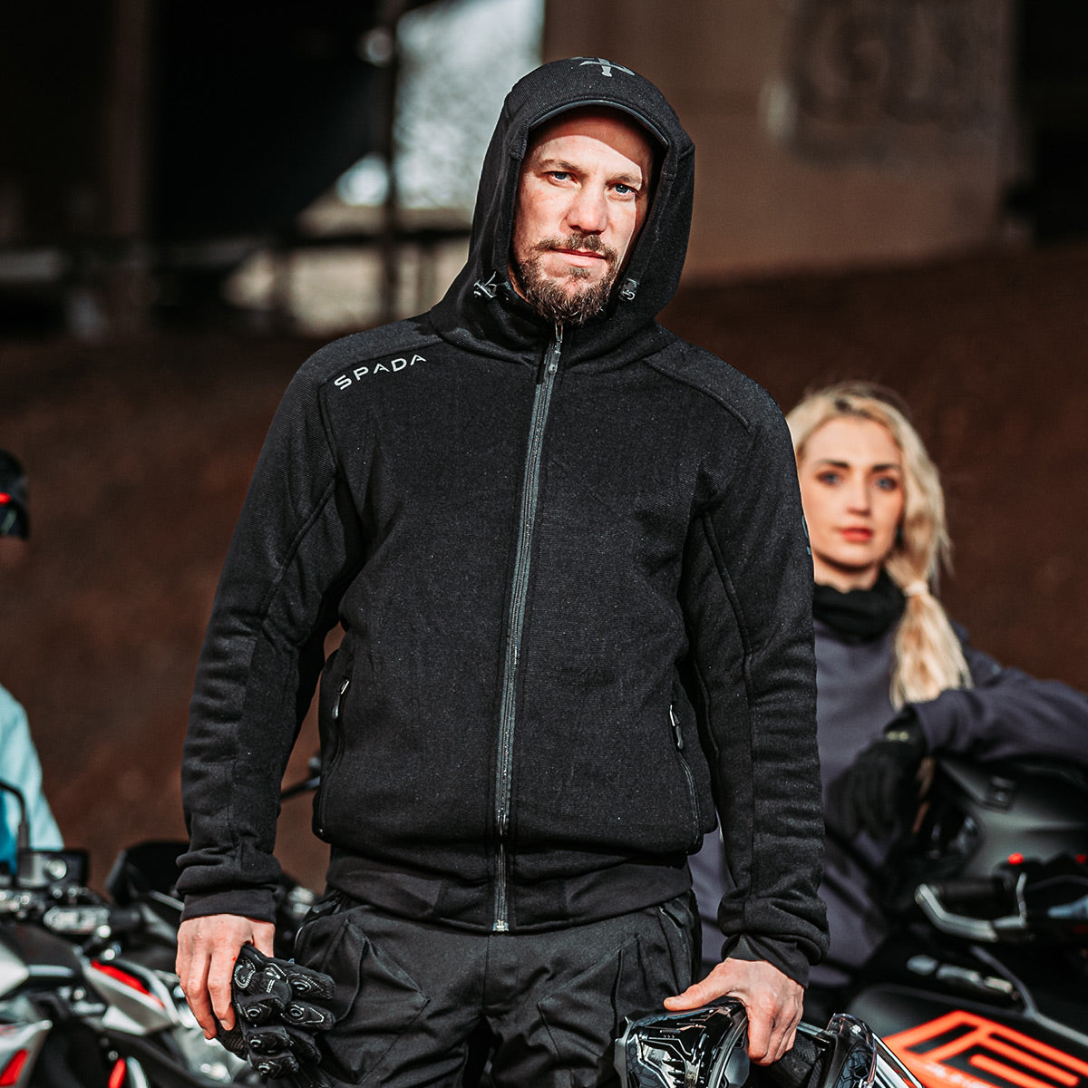 Male biker wearing Blade Black motorcycle hoodie fully zipped with hood up – ready for city rides or casual pit stops